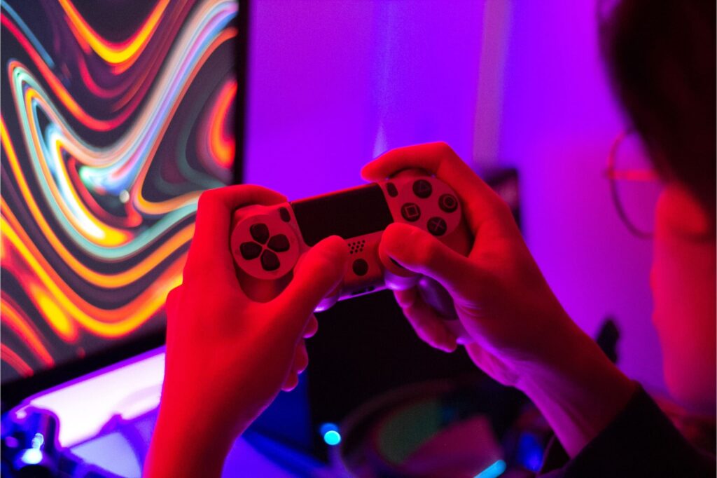 Person using Playstation controller to play video game