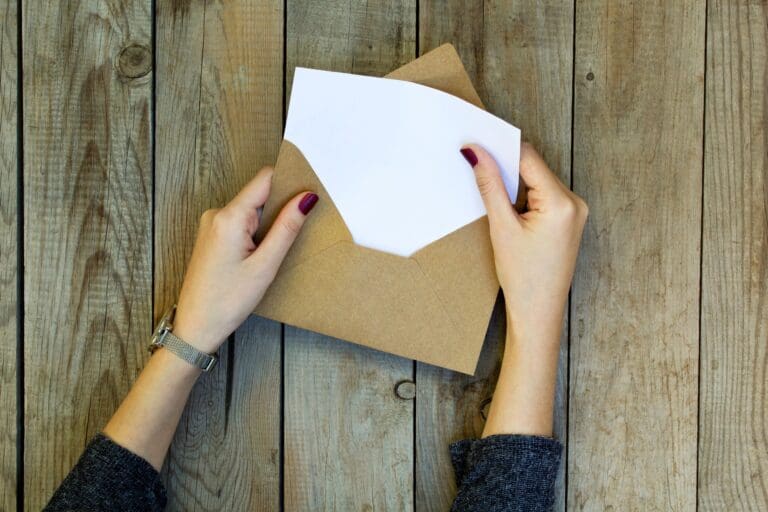 Female student opening envelope with exam results