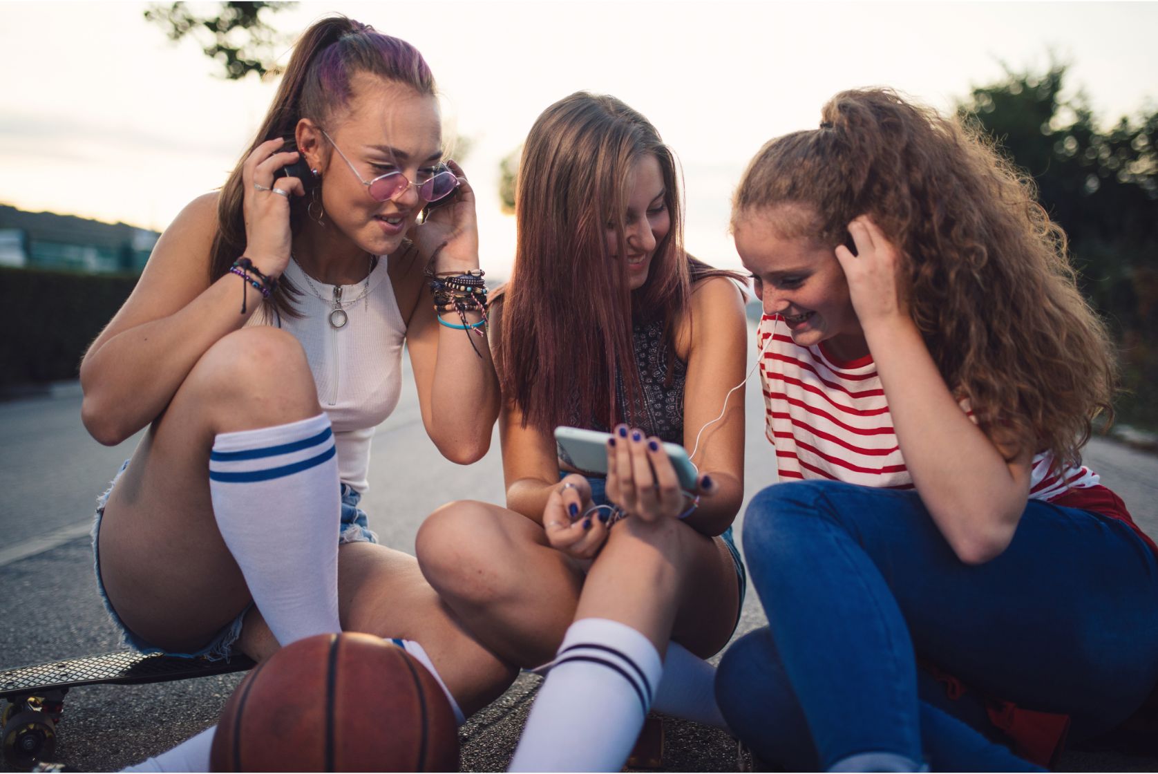 Young female friends listening to music together