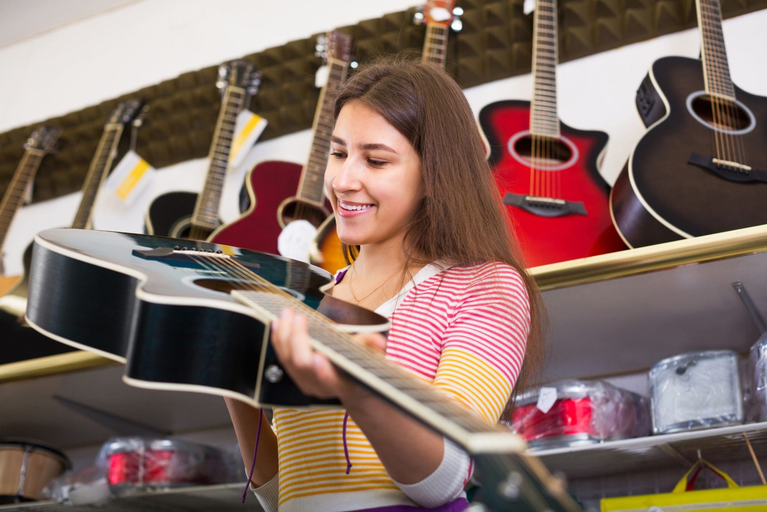 Young female purchasing her first guitar