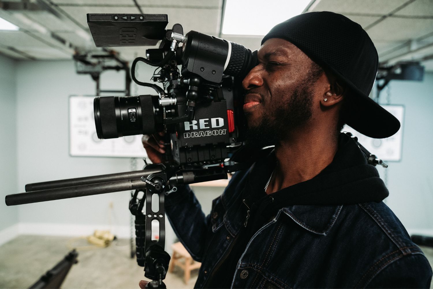 Man with backward cap holding a camera