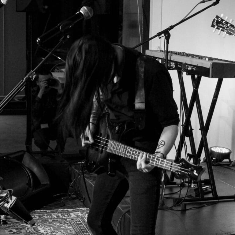 Connor Dawson from Level 2 Music playing guitar in black and white