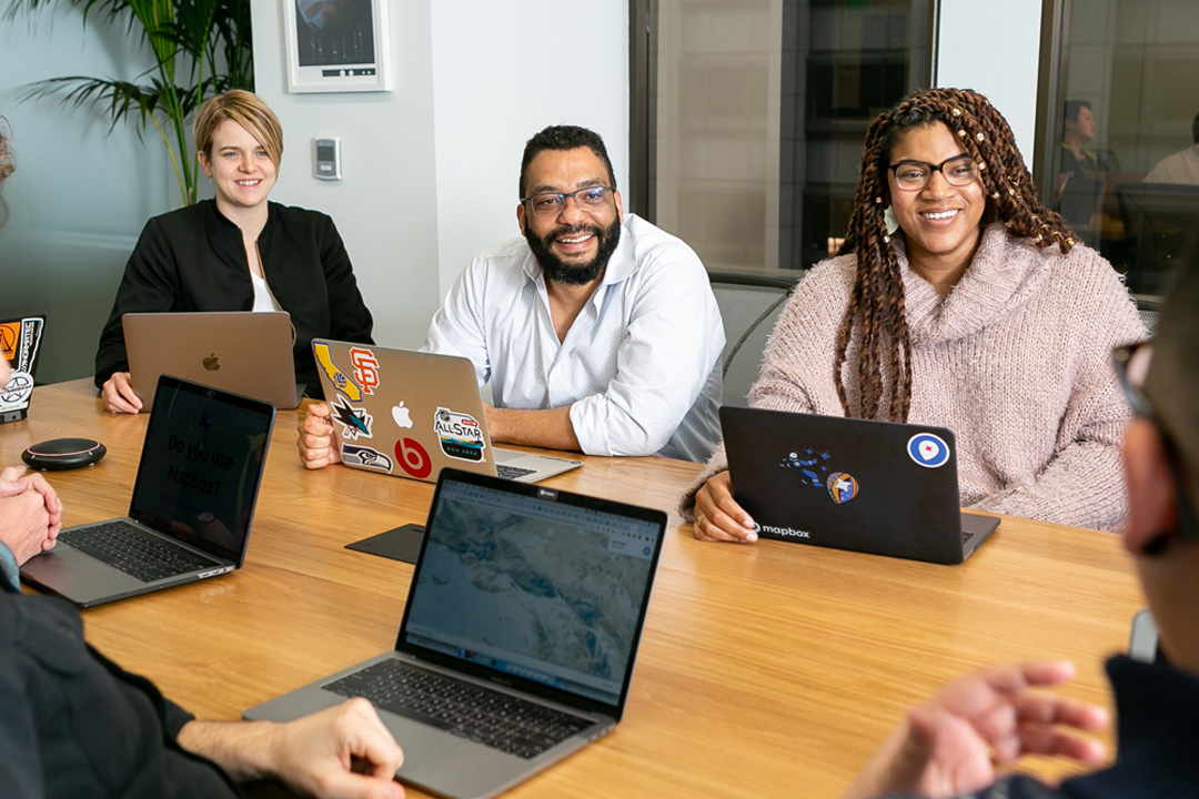 Employers creating strategy in meeting while smiling