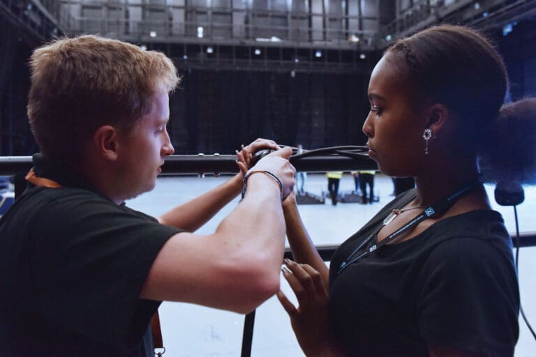 Apprentice event venue technicians fixing cabling