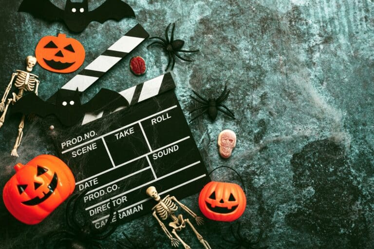 Horror themed clapperboard for filming, with pumpkins and skeletons next to the board