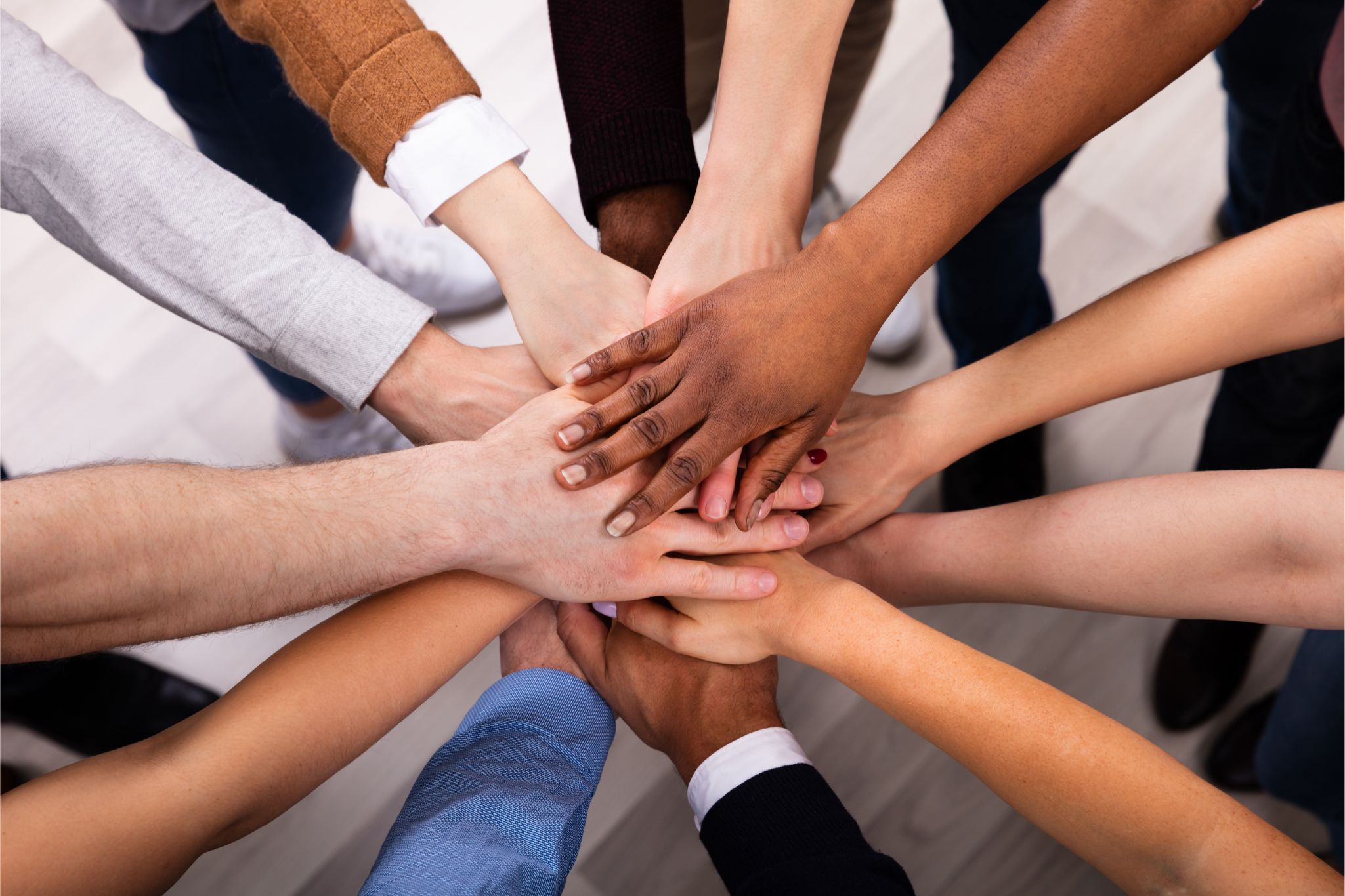 Diverse staff putting hands together